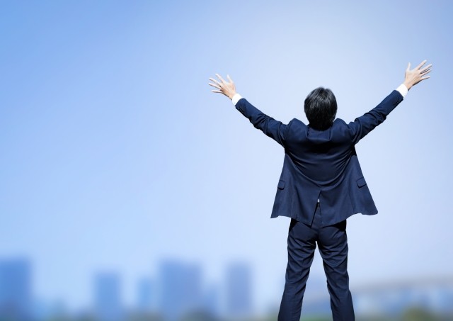 両手を万歳している男性後ろ姿